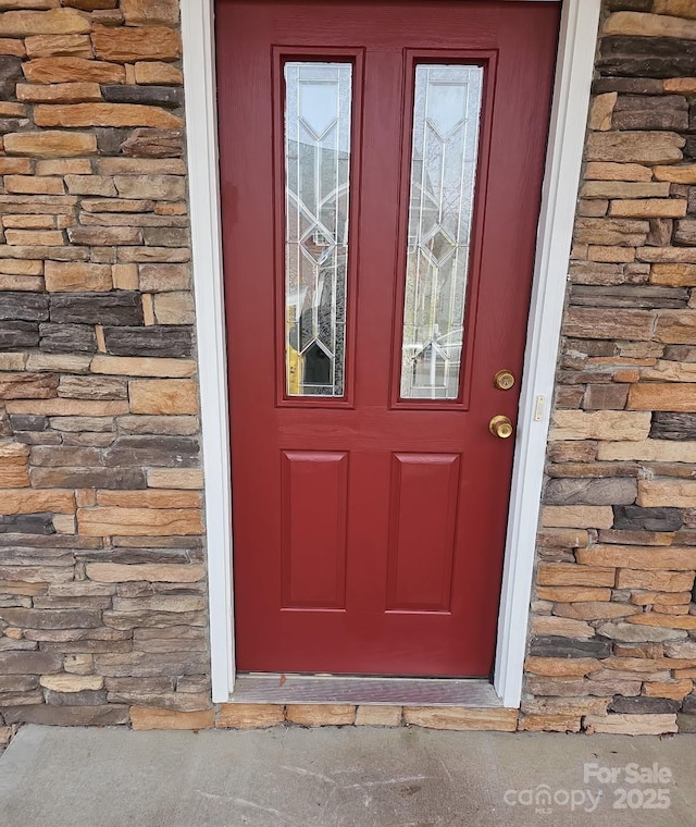 view of exterior entry featuring stone siding