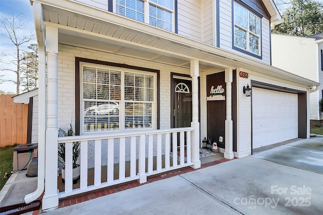 doorway to property with a garage and a porch