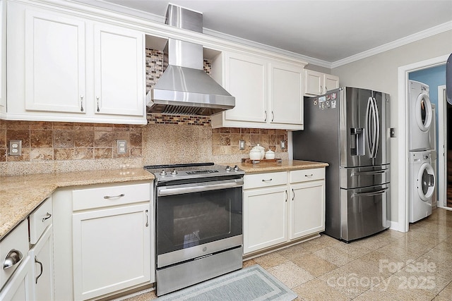 kitchen featuring stacked washer and dryer, appliances with stainless steel finishes, and white cabinets