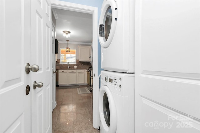 washroom featuring stacked washer / dryer and sink