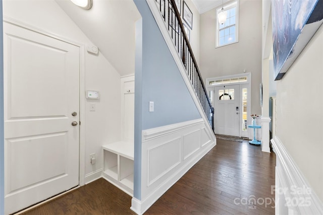 foyer entrance with dark hardwood / wood-style flooring and vaulted ceiling