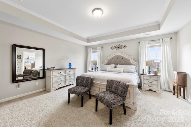 bedroom with light colored carpet, a raised ceiling, and multiple windows