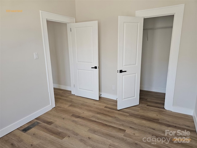 unfurnished bedroom with wood-type flooring and a closet