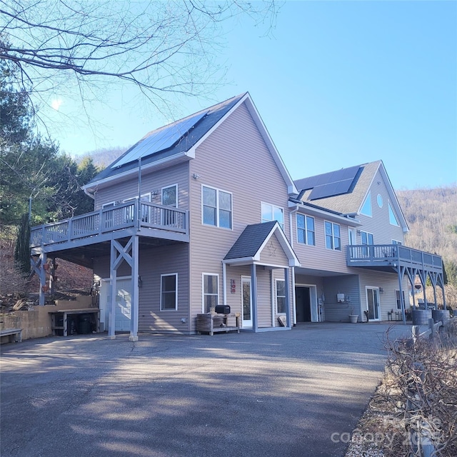 view of front of house featuring roof mounted solar panels, driveway, and a garage