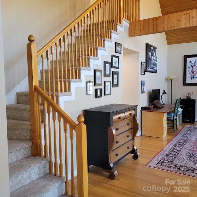 stairway with a high ceiling and wood finished floors