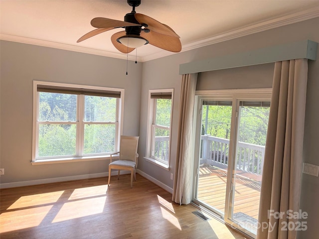 sitting room featuring baseboards, visible vents, ornamental molding, and wood finished floors