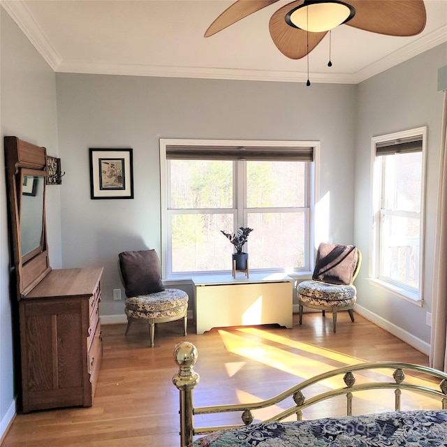 sitting room with a ceiling fan, baseboards, ornamental molding, and light wood-type flooring
