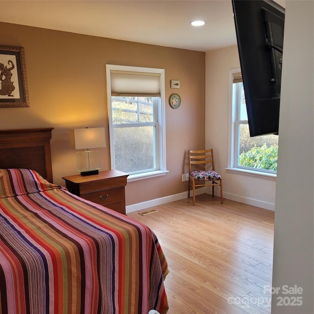 bedroom with recessed lighting, baseboards, multiple windows, and light wood finished floors
