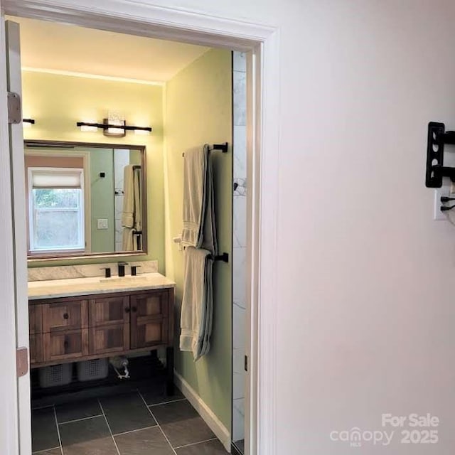 bathroom with vanity, baseboards, and tile patterned flooring