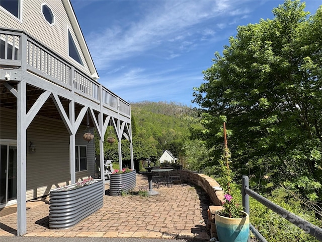 view of patio with a deck and a forest view