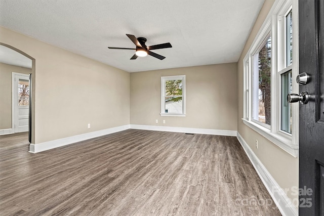 unfurnished room with ceiling fan, hardwood / wood-style floors, and a textured ceiling