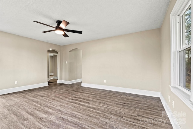 spare room featuring a textured ceiling, dark wood-type flooring, and ceiling fan