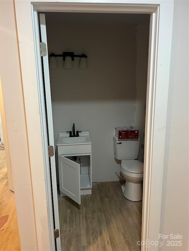 bathroom with sink, hardwood / wood-style flooring, and toilet