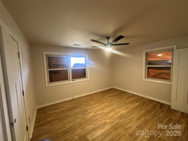 empty room with hardwood / wood-style floors and ceiling fan