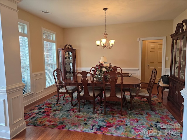 dining space featuring dark hardwood / wood-style flooring and an inviting chandelier