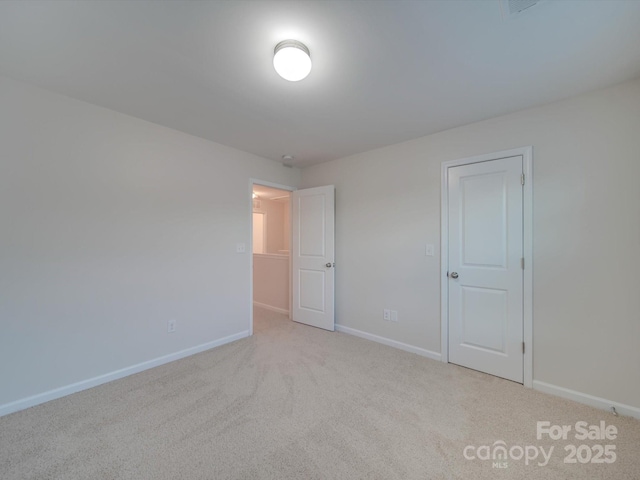 unfurnished room featuring light colored carpet