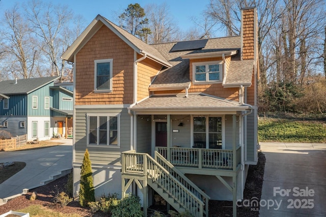 view of front facade featuring solar panels and covered porch