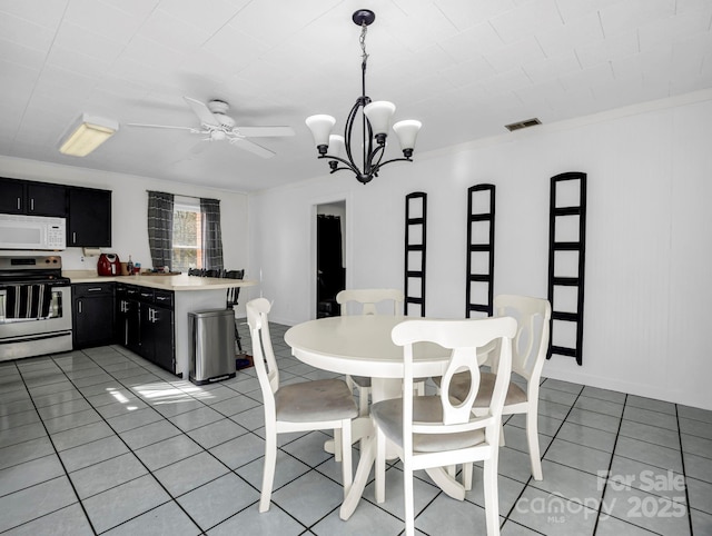 tiled dining space featuring ceiling fan with notable chandelier