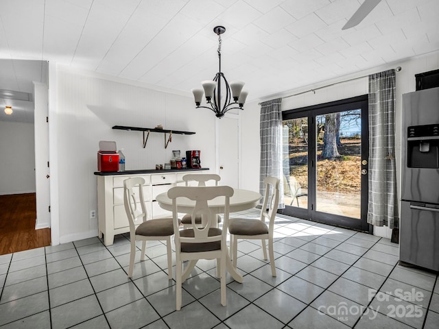 tiled dining space featuring a notable chandelier