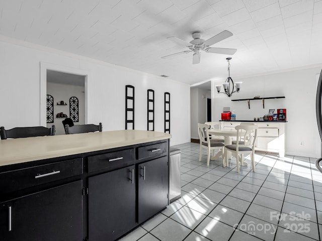 kitchen featuring crown molding, ceiling fan with notable chandelier, hanging light fixtures, and light tile patterned floors