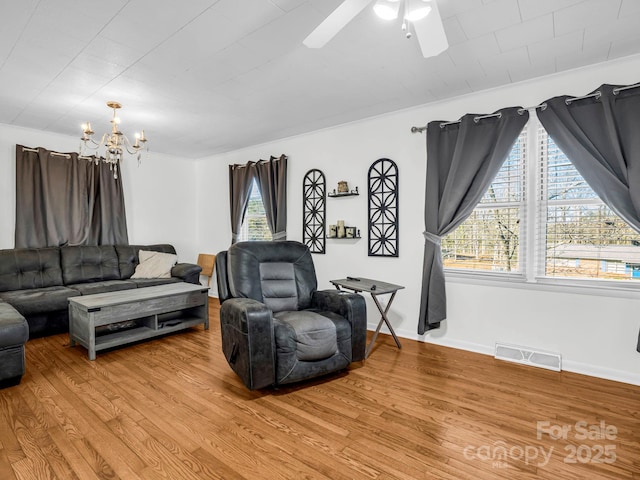 living room featuring hardwood / wood-style flooring and ceiling fan with notable chandelier