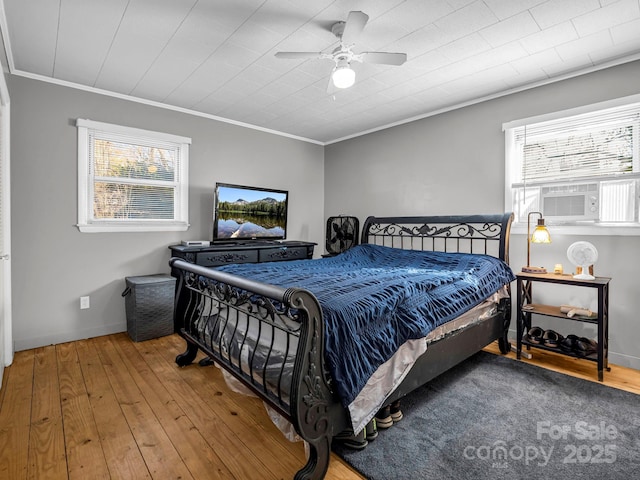 bedroom with multiple windows, hardwood / wood-style floors, and crown molding