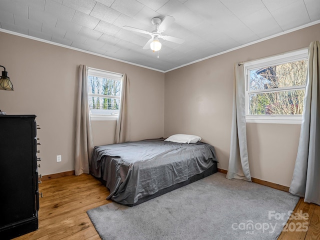 bedroom featuring ceiling fan, ornamental molding, and light hardwood / wood-style floors