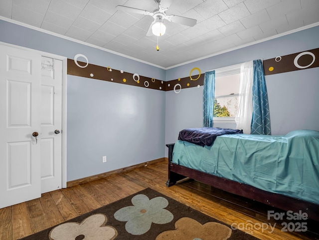 bedroom with wood-type flooring, ornamental molding, and ceiling fan