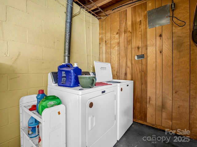 laundry area featuring washing machine and clothes dryer and wooden walls