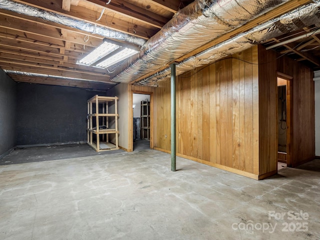 basement featuring wooden walls