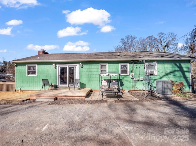 back of house with cooling unit, a wooden deck, and a patio area