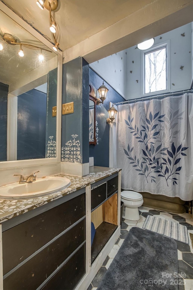 full bathroom with toilet, tile patterned floors, shower / tub combo with curtain, and vanity