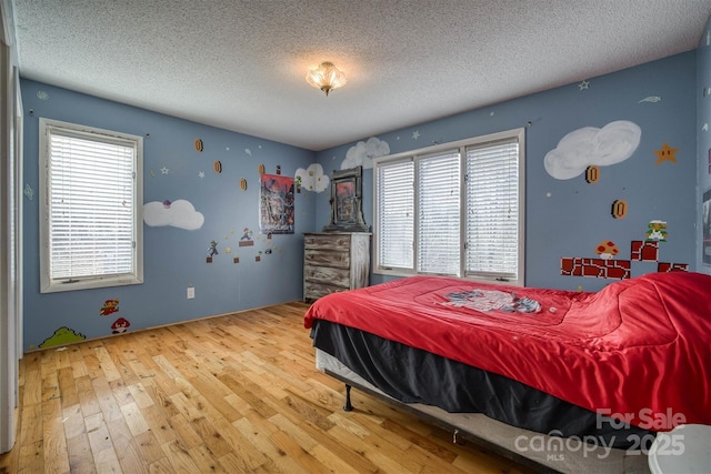 bedroom with hardwood / wood-style floors and a textured ceiling