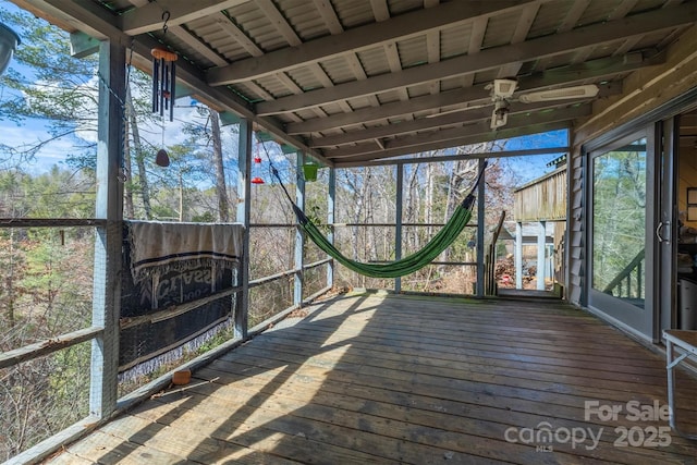 unfurnished sunroom featuring ceiling fan