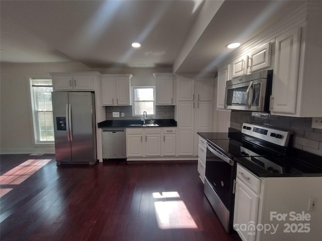 kitchen featuring sink, dark wood-type flooring, white cabinets, and appliances with stainless steel finishes