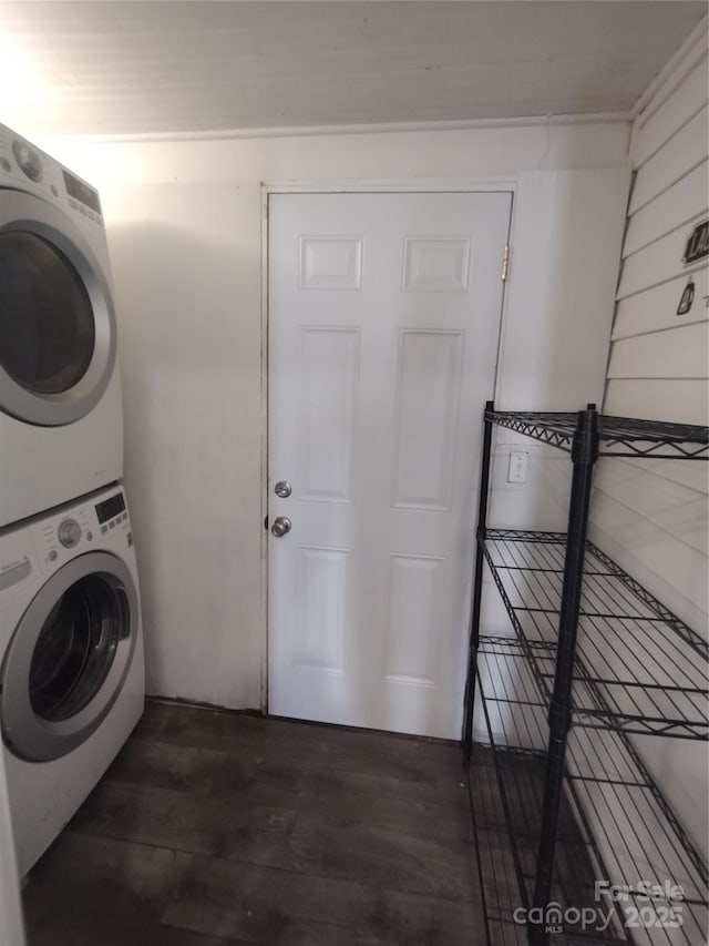 clothes washing area featuring stacked washing maching and dryer and dark hardwood / wood-style flooring