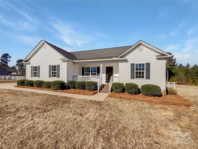 ranch-style house featuring covered porch and a front yard