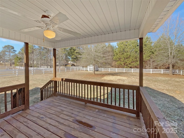 deck featuring a rural view, a lawn, and ceiling fan