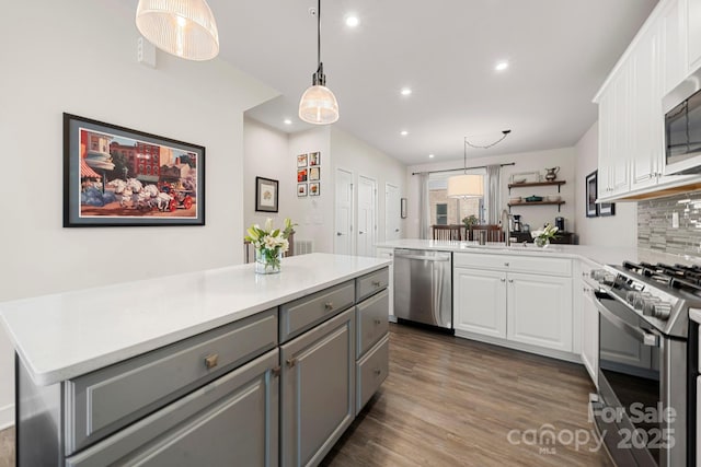 kitchen with gray cabinets, white cabinetry, sink, kitchen peninsula, and stainless steel appliances