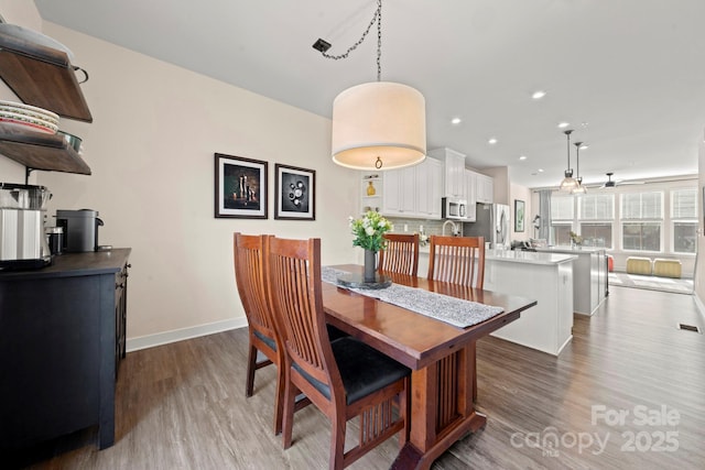 dining space with dark wood-type flooring and ceiling fan