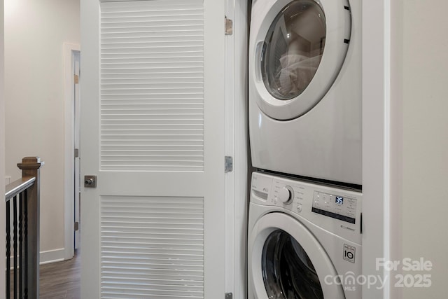 laundry area featuring stacked washer / dryer and dark hardwood / wood-style floors