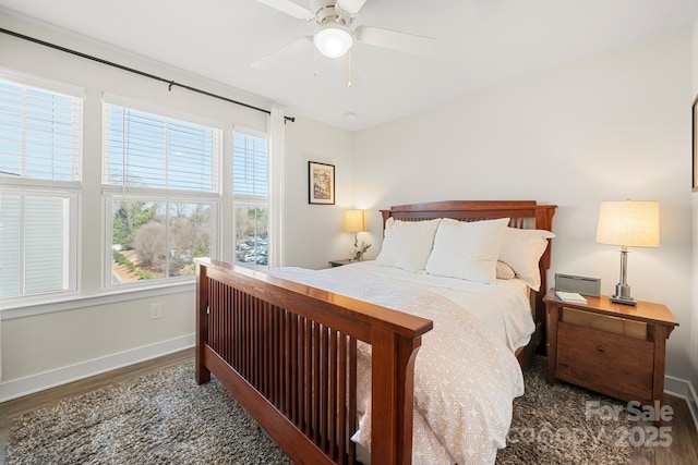 bedroom with ceiling fan, dark hardwood / wood-style flooring, and multiple windows