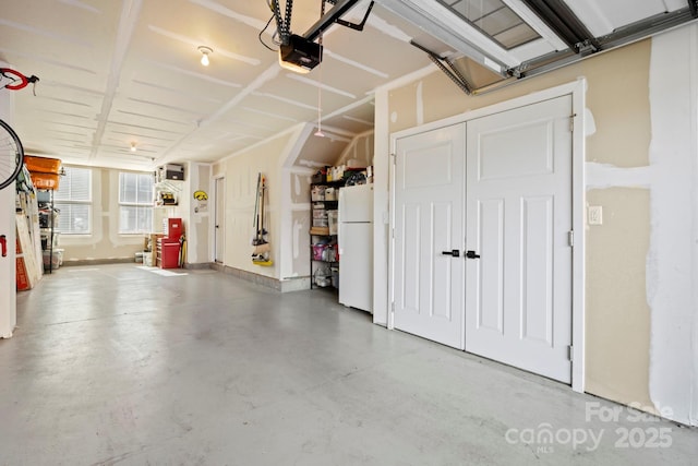 garage with a garage door opener and white fridge