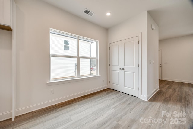 unfurnished bedroom with light hardwood / wood-style floors and a closet