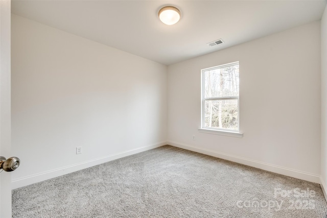 spare room featuring light colored carpet