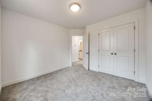 unfurnished bedroom with light carpet and a closet