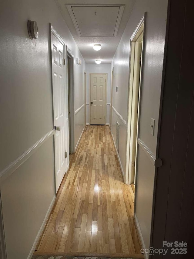 hallway featuring a textured ceiling and light hardwood / wood-style flooring