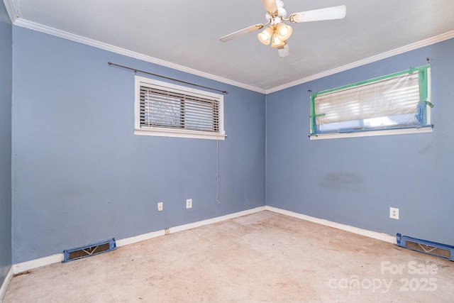 empty room with visible vents, crown molding, and baseboards