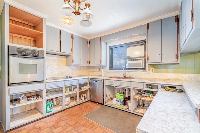 kitchen featuring stainless steel appliances, light countertops, an inviting chandelier, and a sink