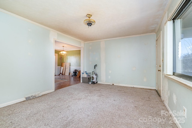 spare room featuring visible vents, baseboards, ornamental molding, and carpet flooring